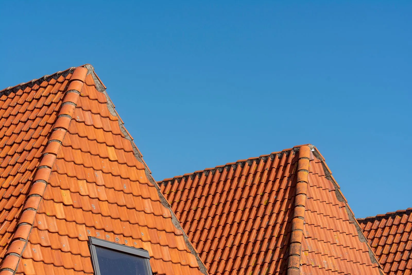 Tiled roof with a skylight window fitted neatly into the pitch