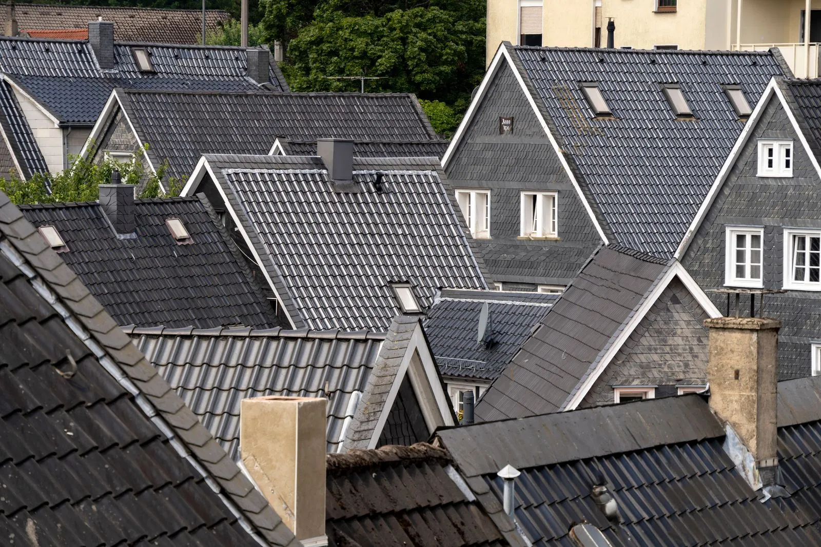 Rows of finished dark-tile roofs across a residential streetscape